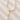 Pearl necklace with a gold chain and pearl pendant on a textured beige surface