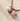 Necklace with seashell and bead charms on a textured beige surface