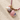 Necklace with seashell and bead charms on a textured beige surface