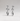 A pair of polished silver drop earrings with a stacked geometric design, featuring a small round bead, an oval bead, and a larger oval drop bead, shown against a neutral light gray background.