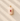 Pink stone pendant with a red gemstone on a textured beige surface