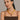 Woman wearing a brown top and yellow necklace against a beige background