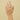 Hand wearing a silver ring and bracelet on a beige background